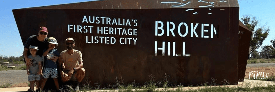 The family find stand in front of Broken Hill sign.